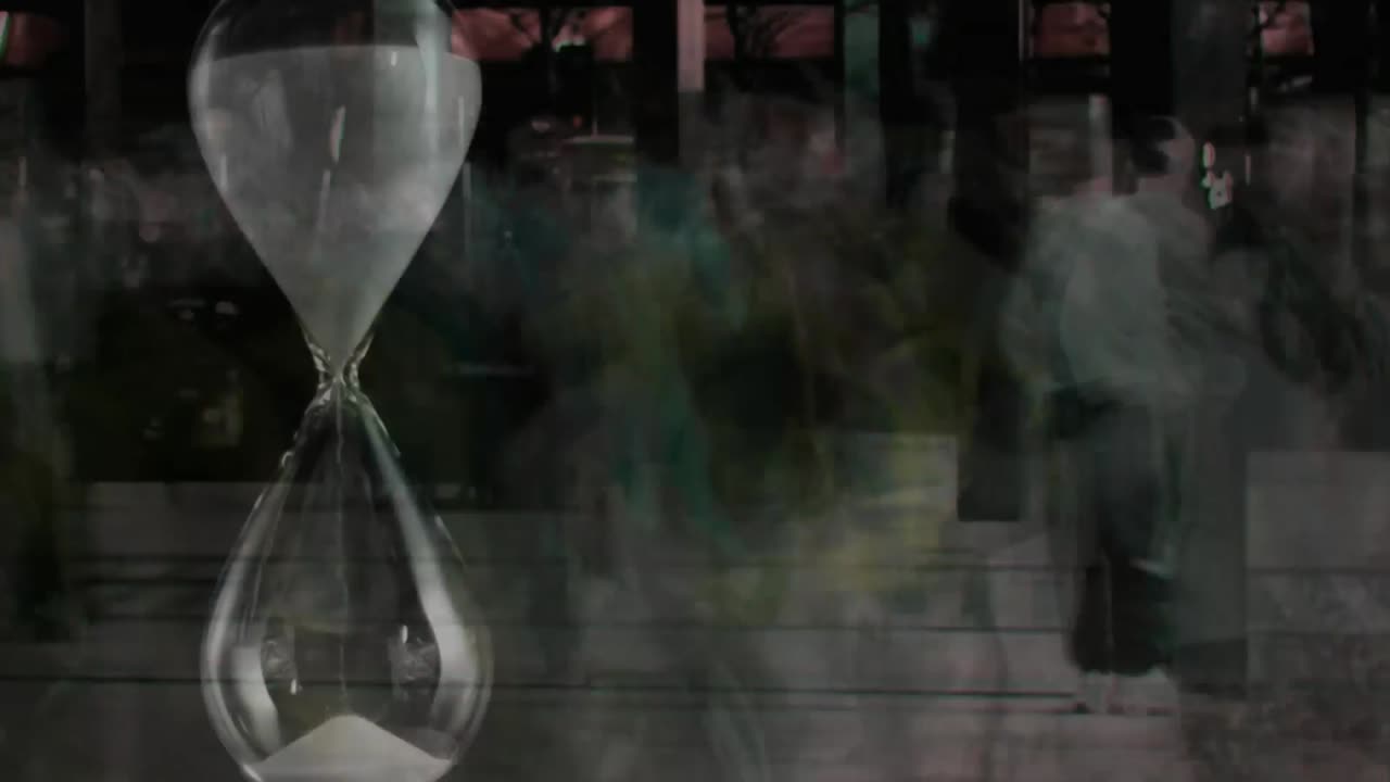 People walking fast with hourglass in the foreground