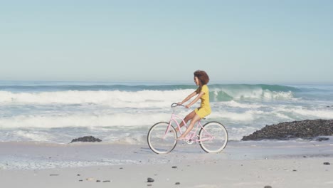 Afroamerikanische-Frau,-Die-Am-Meer-Fahrrad-Fährt