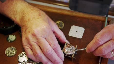 Nahaufnahme-Der-Hände-Eines-Uhrmachers,-Der-Eine-Uhr-Repariert