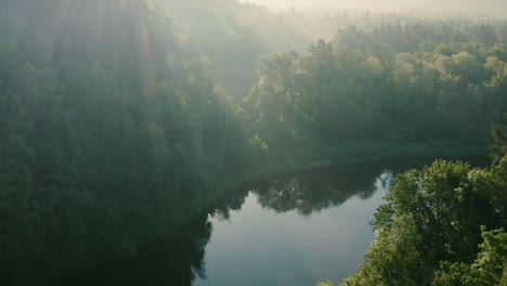 Sonnige-Grüne-Landschaft-Mit-Fluss-Am-Morgen,-Verfolgungsdrohnenaufnahme