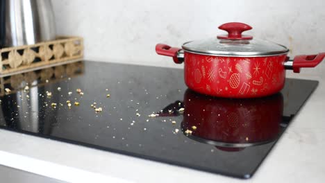 red pot on a dirty stovetop