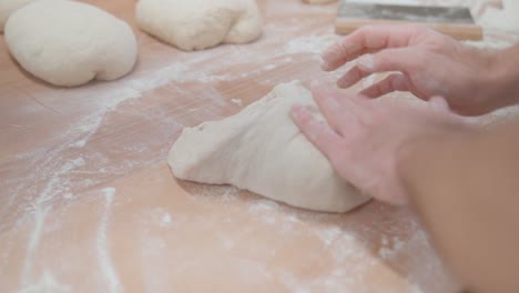 Chef-Amasando-Una-Masa-En-Forma-De-Pan-Sobre-Una-Mesa-En-Harina