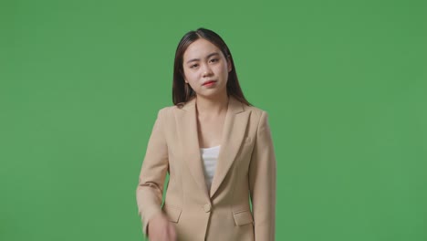 녹색 스크린 앞 에 서 있는 피곤 한 아시아 사업가