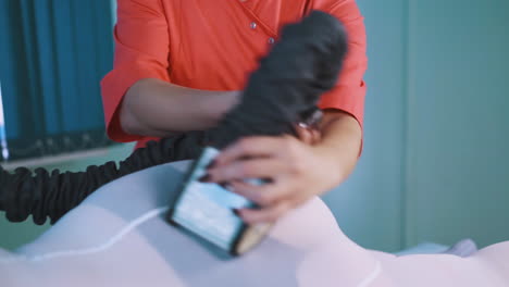 esteticista en uniforme hace masaje con rodillos de vacío a la mujer