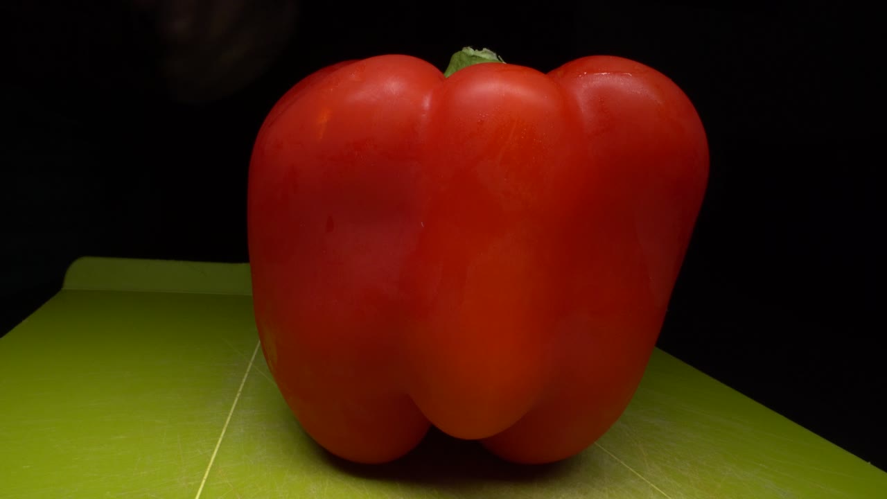Knife Cutting Red Bell Pepper In Two Halves.