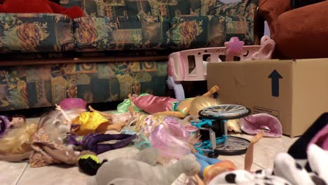 sala para juegos infantiles con muchos juguetes tirados en el suelo creando cajas desordenadas con muñecas, tiro desde abajo viajando hacia atrás, primer plano, ordes, galicia, españa