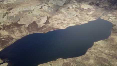 Aerial-footage-of-Loch-nan-Eun-looking-towards-Loch-Ness-on-a-sunny-day,-Scottish-Highlands,-Scotland