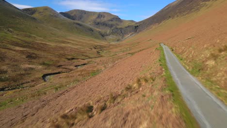 Volando-Sobre-Una-Pista-De-Grava-Vacía-Hacia-Las-Montañas-En-Primavera-Cerca-De-La-Mina-Force-Crag-Coledale-Beck-En-El-Distrito-Inglés-De-Los-Lagos