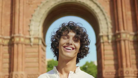 Portrait-of-joyful-man-laughing-outdoor.-Cute-man-smiling-at-urban-background.