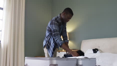 man packing suitcase in bedroom, preparing for holiday travel with excitement