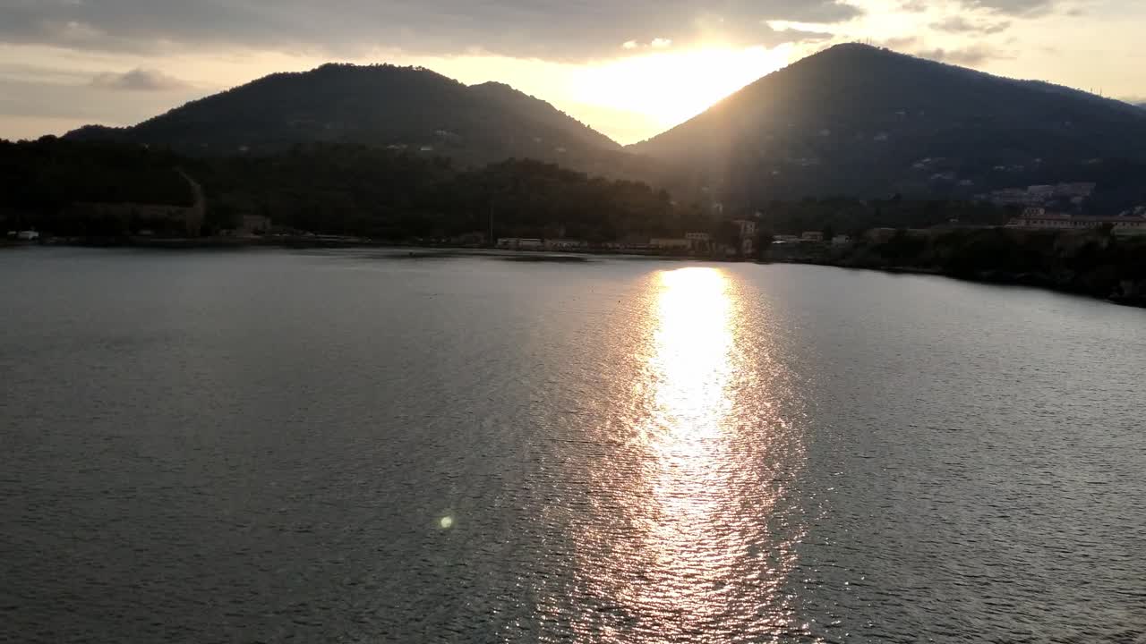 Serene view of Naples Bay at sunset, capturing the mountains and peaceful waters