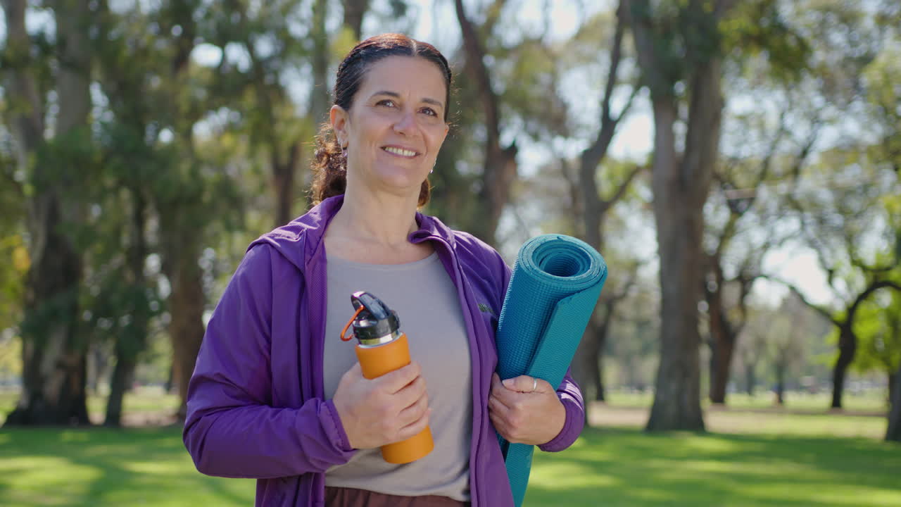 Woman with Yoga Mat and Water Bottle in a Park