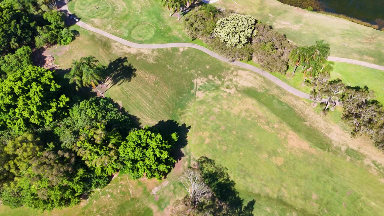 Aerial view of a golf course with trees and a pond