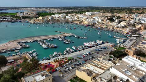 Luftaufnahmen-Von-Marsaxlokk-–-Traditionelles-Fischerdorf-Im-Südosten-Maltas,-Mit-Bunten-Fischerbooten-In-Der-Bucht