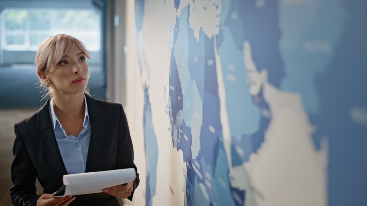 Employee looking world map in monitoring office closeup. Woman analyst working