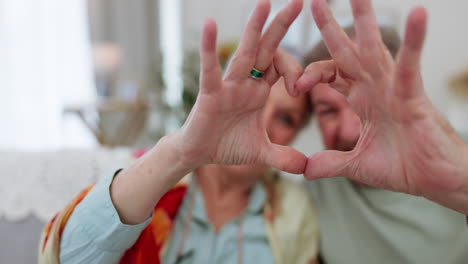 heart hands, face and senior couple on sofa happy