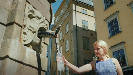 Eine-Frau-Holt-Wasser-In-Einer-Flasche-Aus-Einem-Brunnen-Auf-Dem-Zentralen-Platz-Von-Stockholm-Sauber-Trinken