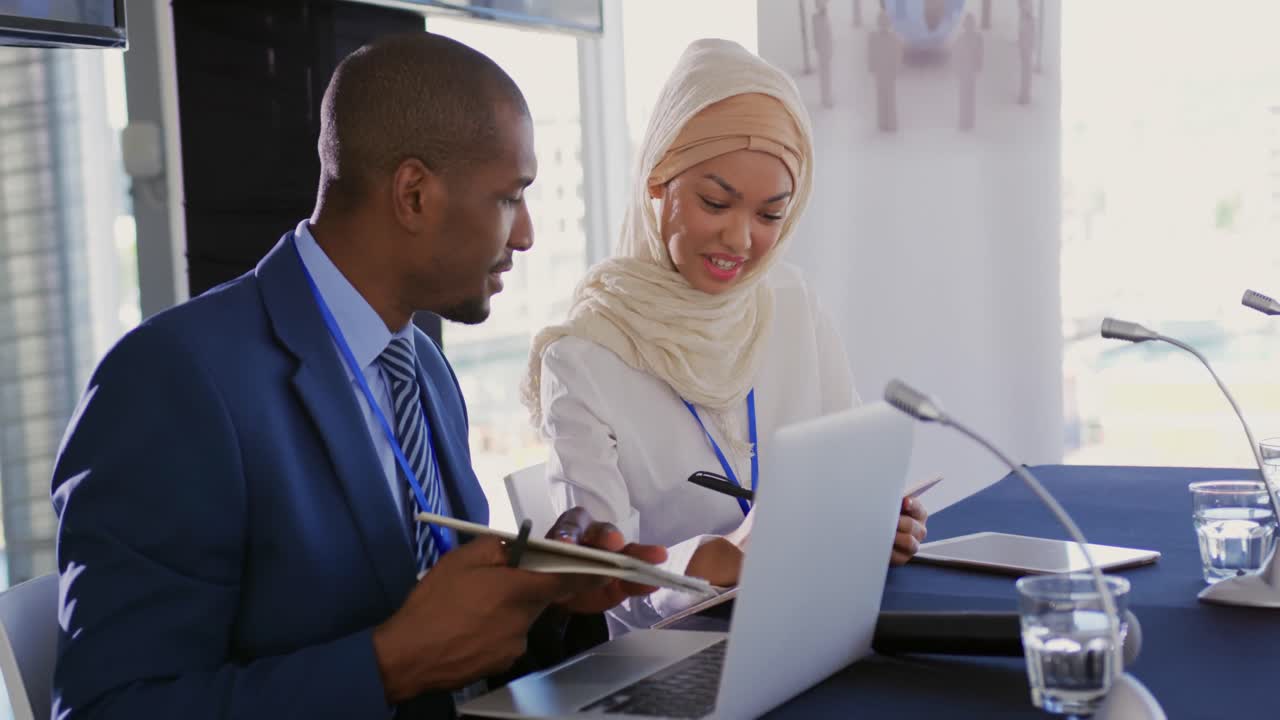 Two delegates talking making notes at a business conference