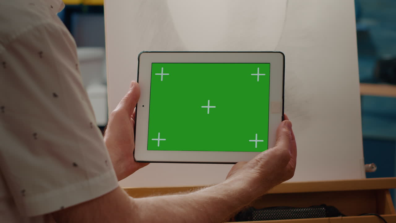 Creative artist looking at horizontal greenscreen on digital tablet