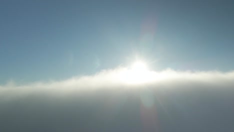 Flying-Over-Clouds-Backlit-Sunlit-During-Late-Afternoon-In-Ireland