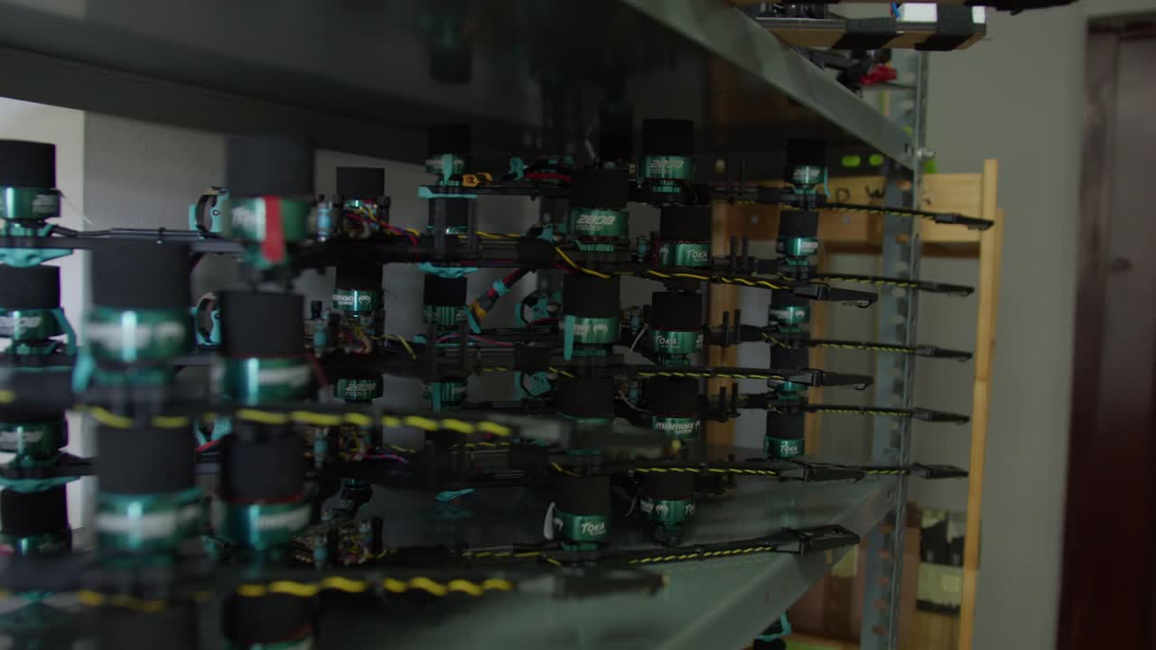 Multiple FPV Racing Drones Arranged on Metal Storage Shelf in Drone Workshop