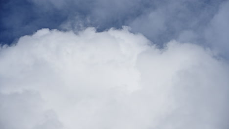 Vast-expanse-of-billowing-white-clouds-against-a-blue-sky,-captured-in-a-timelapse