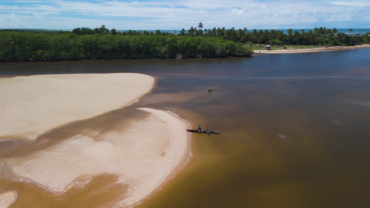 AERIAL: Traditonal fishing boat arriving at a sandbank on De Contas river in Brazil