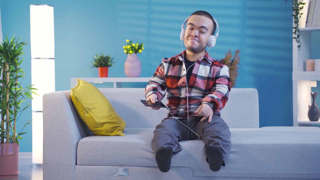un joven enano discapacitado feliz escuchando música con auriculares divirtiéndose y manteniendo el ritmo de baile.