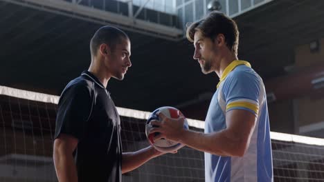 Aggressive-Männliche-Volleyballspieler,-Die-Sich-Gegenseitig-Durch-Das-Netz-Schauen,-4k