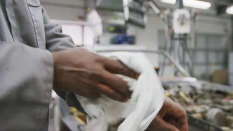 Afroamerikanischer-Männlicher-Automechaniker,-Der-Seine-Hände-Mit-Einem-Lappen-Reinigt