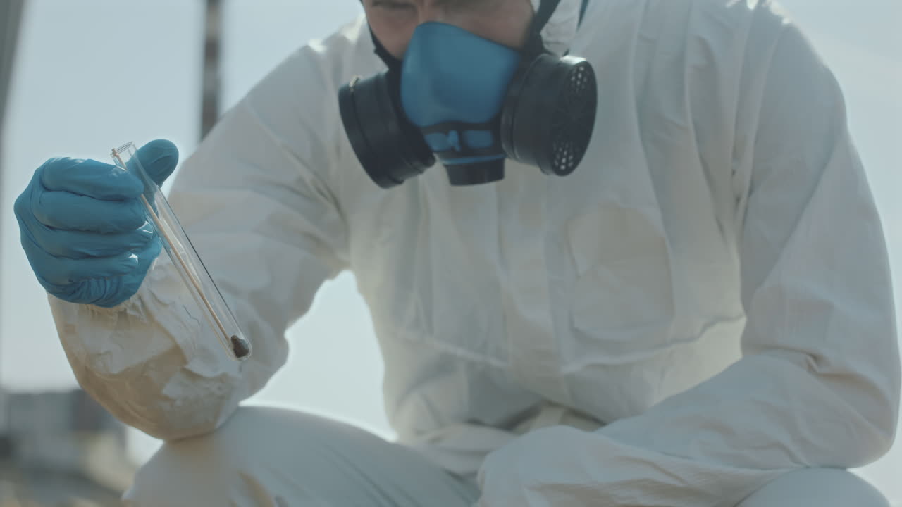 Ecologist in Protective Suit Collecting Sample of Soil