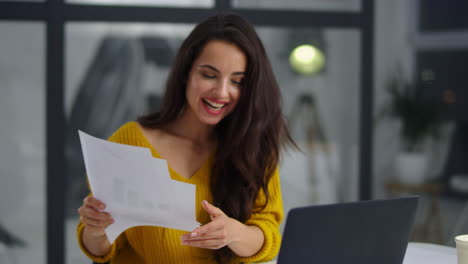 mujer de negocios sonriente leyendo documentos. chica alegre obteniendo buenos resultados