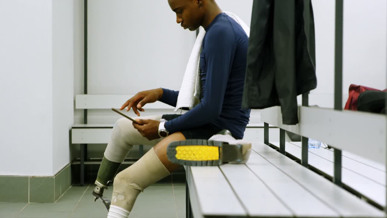 hombre discapacitado usando tableta digital en el vestuario 4k