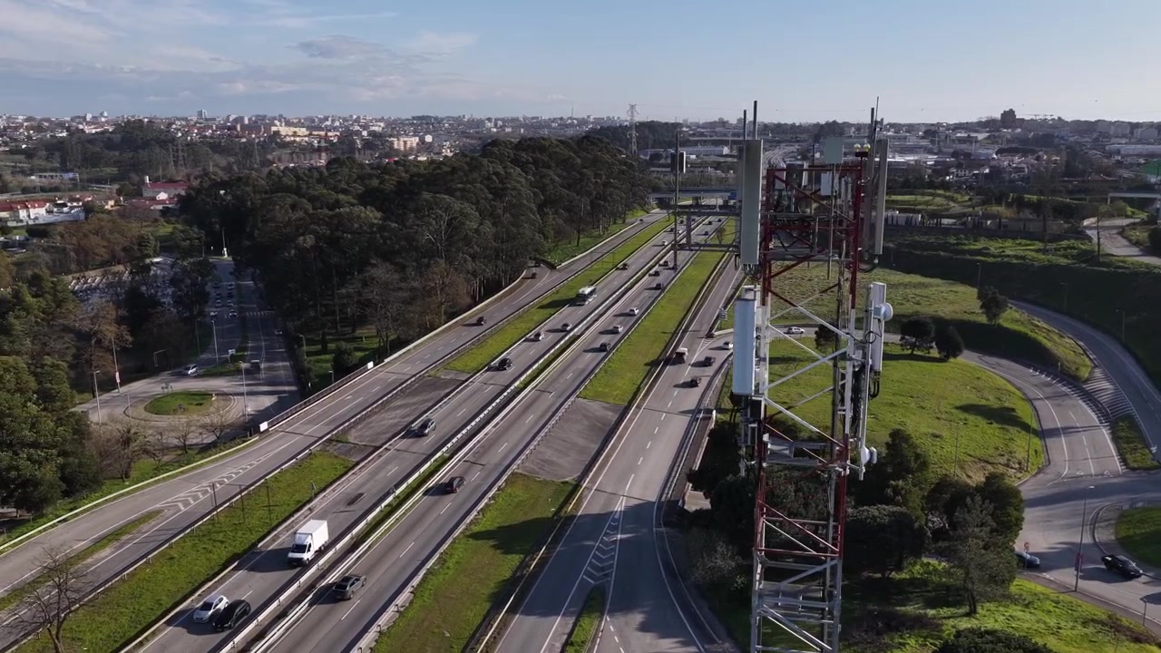 Vista aérea de una torre de tecnología de comunicaciones móviles cerca de una autopista. Antena 5G y 6G