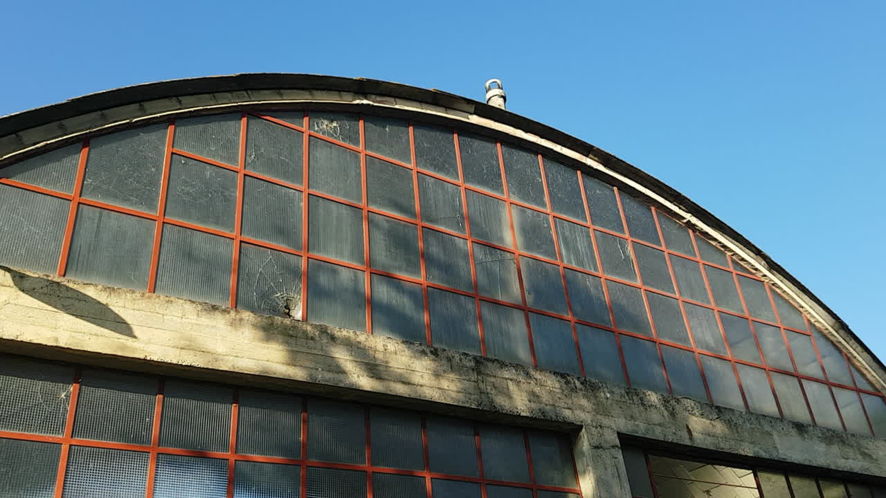 Tilt down shot of a old asbestos industrial hangar at a sunny day. Sieci, Pontassieve. Italy