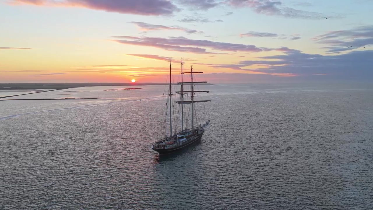 Terschelling'de doğal bir Hollanda gün batımı sırasında seyreden Gulden Leeuw yelkenli gemisi