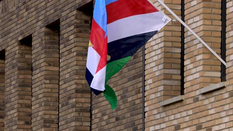 flag of national veterans day hanging from a window pane blowing to commemorate and draw attention to the military service of dutch veteran community