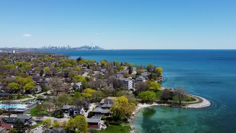 Flying-around-sunny-Lake-Ontario-lakeshore-with-the-city-of-Toronto-in-the-distance
