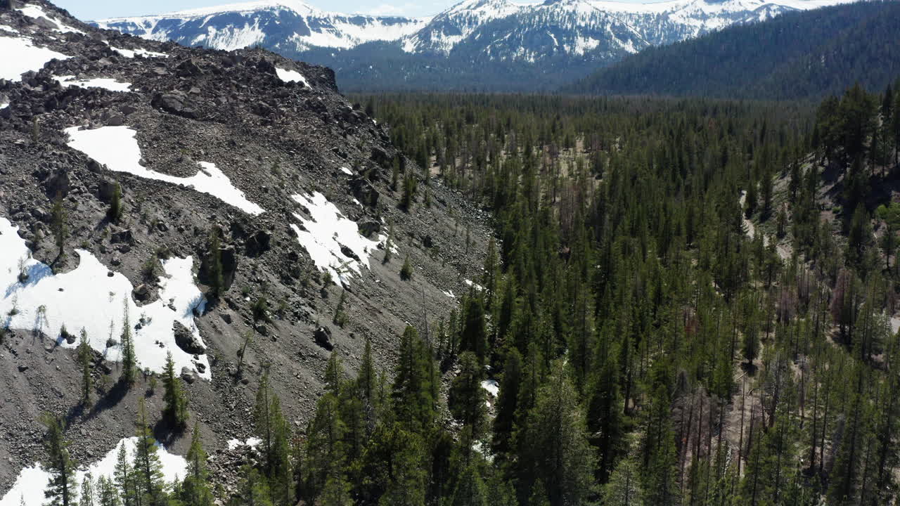 montañas de la sierra nevada en california con manchas de nieve y denso bosque verde, vista aérea