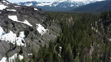 Sierra-nevada-mountains-in-california-with-snow-patches-and-dense-green-forest,-aerial-view