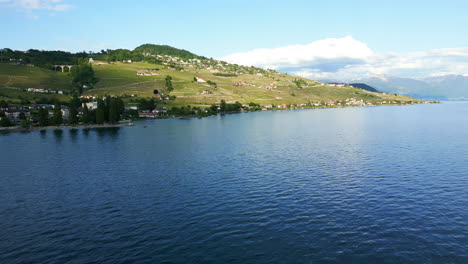 dolly in drone shot of lavaux terraced vineyards and lake geneva during the day near lutry in canton of vaud, switzerland