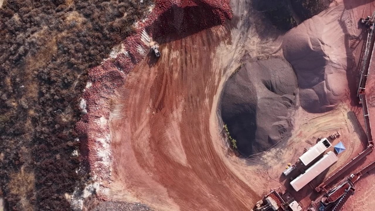 Aerial Top Down View of Earth Movers at a massive Clay Mining Facility shows the Red Clay deposits being moved and Separated for Processing