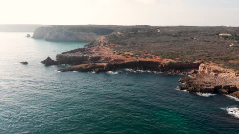 aerial: rock formations and moving water in the algarve portugal