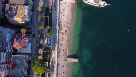 Vista-Aérea-De-Arriba-Hacia-Abajo-Sobre-El-Paseo-Marítimo-De-Sarande,-Albania-Junto-A-La-Playa