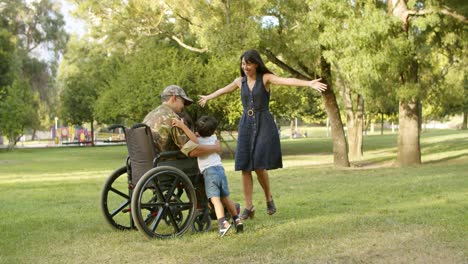 niños felices y su madre corriendo hacia un padre militar discapacitado