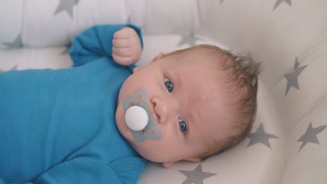 little-baby-with-dummy-rests-in-cocoon-in-rocking-cot