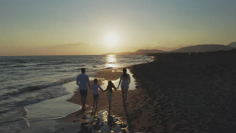 family enjoying a sunset walk on the beach