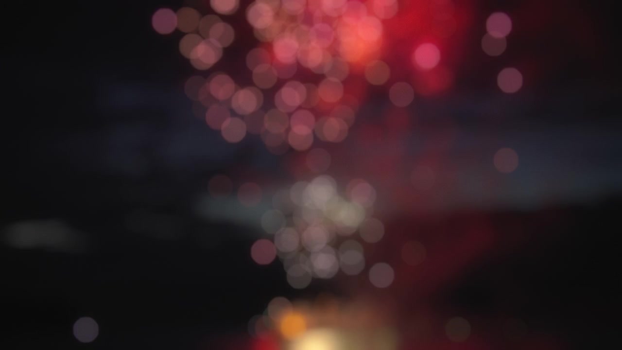 Spettacolo di fuochi d'artificio colorati su sfondo bokeh astratto e sfocato. Movimento rallentato.