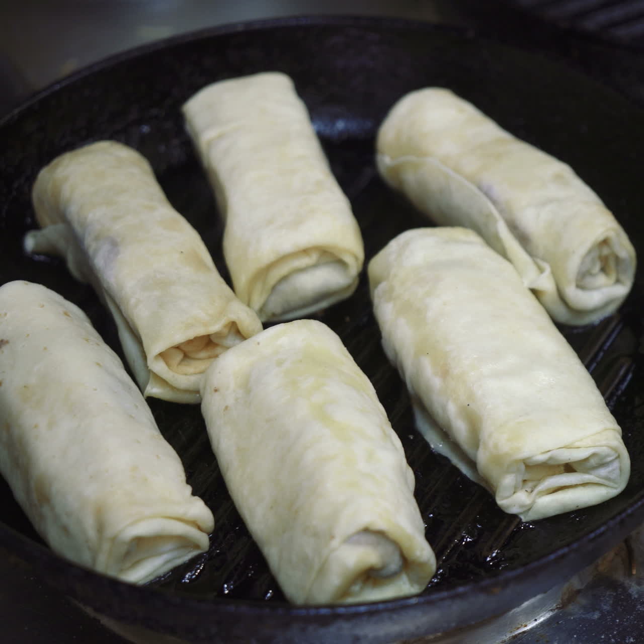 Frying pancakes with fillings on a skillet. Traditional kitchen. Sqare video