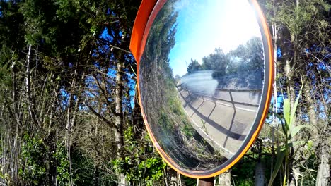 un primer plano de un espejo de tráfico convexo en una carretera rural en cerdeña, italia